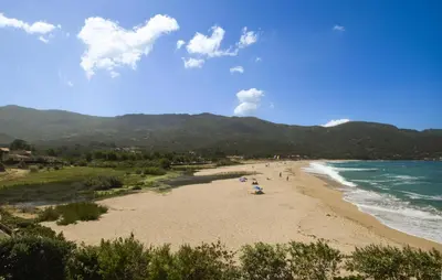 a beach with people on the sand and the ocean at Nice Home In Sagone With Wi-Fi in Sagone
