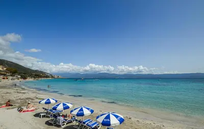 a beach with blue and white umbrellas and the ocean at 2 Bedroom Stunning Apartment In Afa in Afa