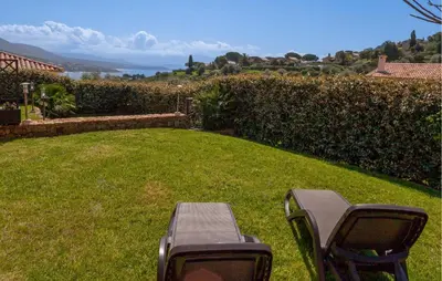 a couple of chairs sitting in the grass at Beautiful Home In Sagone With Kitchen in Sagone