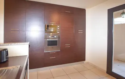 a kitchen with wooden cabinets and an oven at Beautiful Home In Sagone With Kitchen in Sagone