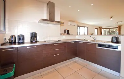a large kitchen with brown cabinets and a sink at Beautiful Home In Sagone With Kitchen in Sagone