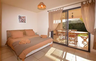 a bedroom with a bed and a balcony with a table at Beautiful Home In Sagone With Kitchen in Sagone