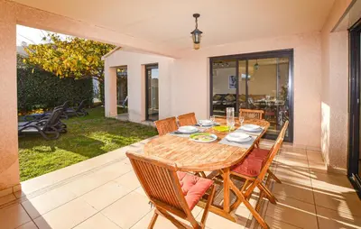 a wooden table and chairs on a patio at Beautiful Home In Sagone With Kitchen in Sagone