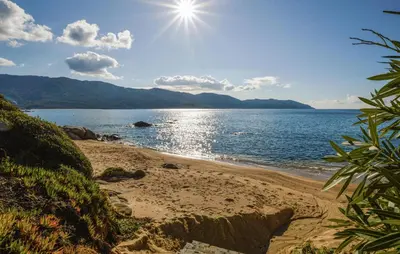 a beach with the sun shining on the water at Beautiful Home In Sagone With Kitchen in Sagone