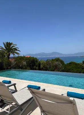 a couple of chairs and a swimming pool at VILLA RIVOLI vue mer et piscine in Pietrosella