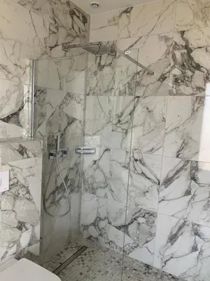 a bathroom with a shower with a glass door at VILLA NAPOLEON vue mer et piscine in Pietrosella