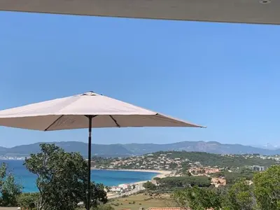 a white umbrella with a view of the ocean at VILLA NAPOLEON vue mer et piscine in Pietrosella
