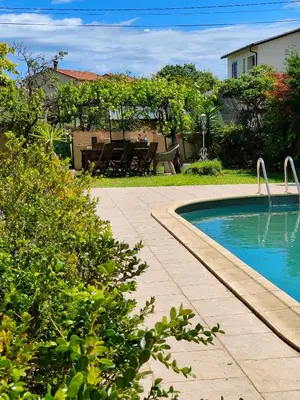 a swimming pool in a yard with a table and bench at Maison de campagne piscine et jardin privatifs près de la plage in Aléria