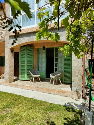 two chairs sitting on the front porch of a building at Maison de campagne piscine et jardin privatifs près de la plage in Aléria