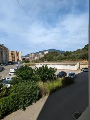 a parking lot with cars parked in a city at Appartement 3 chambres - 2 salles de bain - 6 personnes in Ajaccio