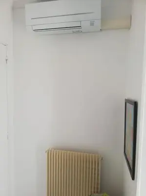 a white room with a radiator and a window at Appartement 3 chambres - 2 salles de bain - 6 personnes in Ajaccio
