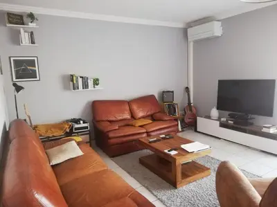 a living room with a leather couch and a coffee table at Appartement 3 chambres - 2 salles de bain - 6 personnes in Ajaccio