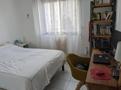 a bedroom with a bed and a desk with a laptop at Appartement 3 chambres - 2 salles de bain - 6 personnes in Ajaccio