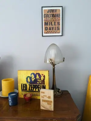 a table with a lamp and a movie poster on it at Appartement 3 chambres - 2 salles de bain - 6 personnes in Ajaccio