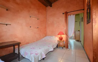 a bedroom with a bed and a lamp on a table at Lovely Apartment In Poggio Di Nazza in Poggio-di-Nazza