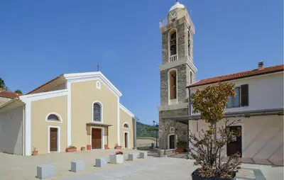 a church with a clock tower next to a building at Lovely Apartment In Poggio Di Nazza in Poggio-di-Nazza