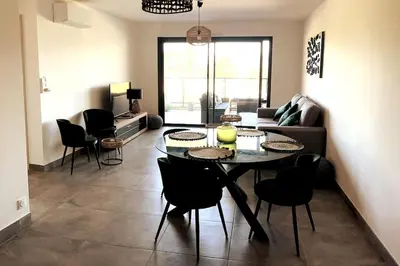 a living room with a table and chairs at Appartement avec terrasse 3 pièces - Vue mer - Plage 5 min à pied in Propriano
