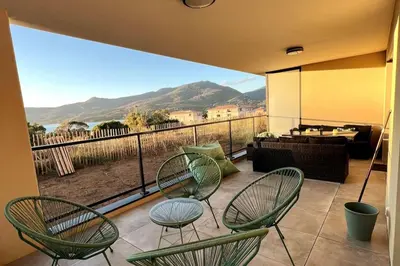 a balcony with chairs and a view of a living room at Appartement avec terrasse 3 pièces - Vue mer - Plage 5 min à pied in Propriano