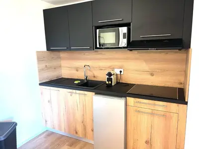 a kitchen with a sink and a microwave at Cala Rossa T2 Neuf à 800 m de la mer appart n 81 in Lecci