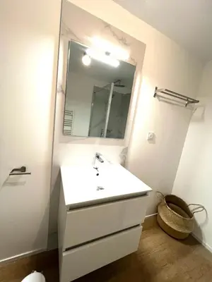 a bathroom with a white sink and a mirror at Cala Rossa T2 Neuf à 800 m de la mer appart n 81 in Lecci