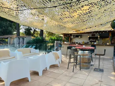 a patio with white tables and chairs and a bar at Cala Rossa T2 Neuf à 800 m de la mer appart n 81 in Lecci