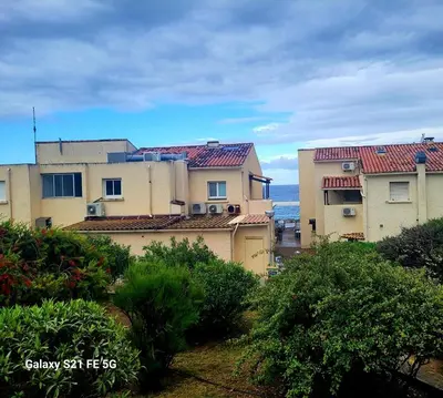 a group of buildings with the ocean in the background at T2 bord de mer Agosta in Albitreccia