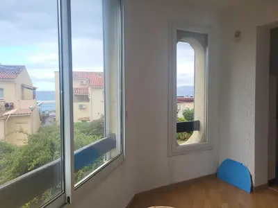 a room with two windows with a view of the ocean at T2 bord de mer Agosta in Albitreccia