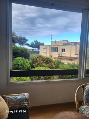 a window with a view of a building at T2 bord de mer Agosta in Albitreccia