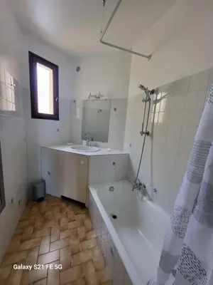 a bathroom with a bath tub and a sink at T2 bord de mer Agosta in Albitreccia