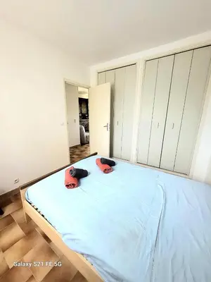 a bedroom with a large bed with blue sheets at T2 bord de mer Agosta in Albitreccia