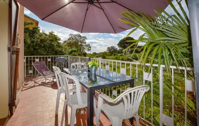 a table and chairs on a balcony with an umbrella at 2 Bedroom Stunning Home In San-Giuliano in San-Giuliano
