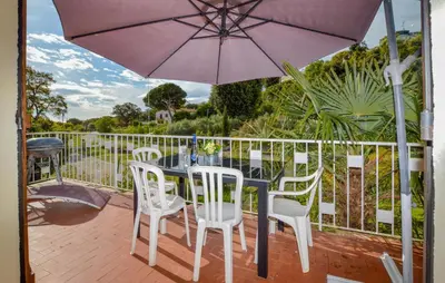 a patio with a table and chairs and an umbrella at 2 Bedroom Stunning Home In San-Giuliano in San-Giuliano