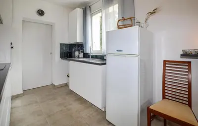a white kitchen with a refrigerator and a window at 2 Bedroom Stunning Home In San-Giuliano in San-Giuliano