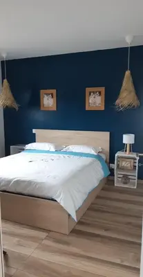a bedroom with a large bed with a blue wall at Maison proche de la mer in Pianottoli-Caldarello