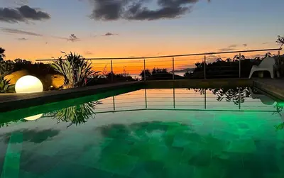a swimming pool with a sunset in the background at villa 4 etoiles 3 chambres vue mer ajaccio in Pietrosella