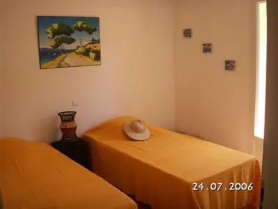 a room with two beds and a picture on the wall at villa 4 etoiles 3 chambres vue mer ajaccio in Pietrosella