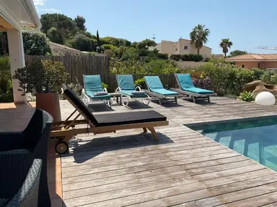 a row of lounge chairs next to a swimming pool at villa 4 etoiles 3 chambres vue mer ajaccio in Pietrosella