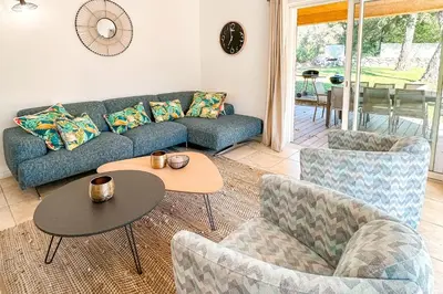 a living room with a couch and chairs and a table at Villa Amaredda Di Arasu in Sainte-Lucie de Porto-Vecchio
