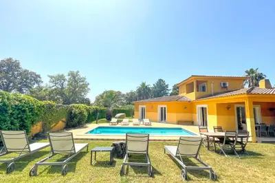a yard with chairs and a pool and a house at Villa Amaredda Di Arasu in Sainte-Lucie de Porto-Vecchio