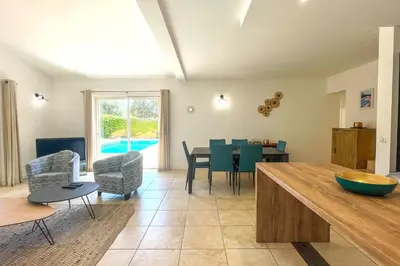 a kitchen and living room with a table and chairs at Villa Amaredda Di Arasu in Sainte-Lucie de Porto-Vecchio