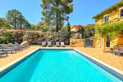 a swimming pool with chairs and a house at Villa Ditalina Di Arasu in Sainte-Lucie de Porto-Vecchio