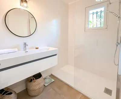 a white bathroom with a sink and a mirror at Villa Ditalina Di Arasu in Sainte-Lucie de Porto-Vecchio