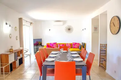 a dining room with a table and orange chairs at Villa Ditalina Di Arasu in Sainte-Lucie de Porto-Vecchio