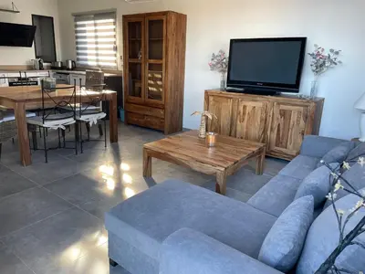 a living room with a blue couch and a tv at Belle Maison avec piscine Furiani in Furiani