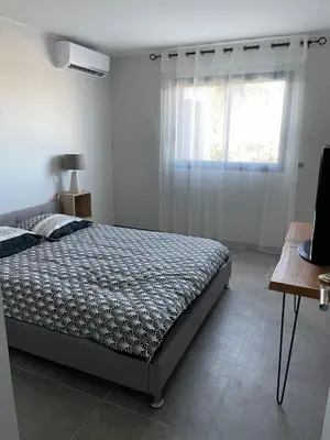 a bedroom with a bed and a window at Belle Maison avec piscine Furiani in Furiani
