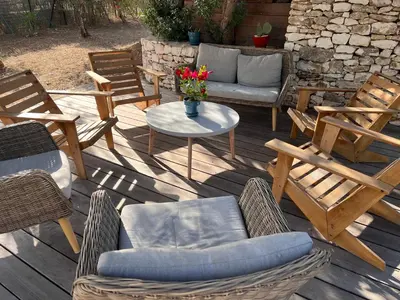 a wooden deck with chairs and a table and a couch at La Casa Soliam in Bonifacio
