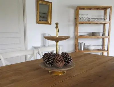 a table with a gold stand with three pine cones on it at La Casa Soliam in Bonifacio
