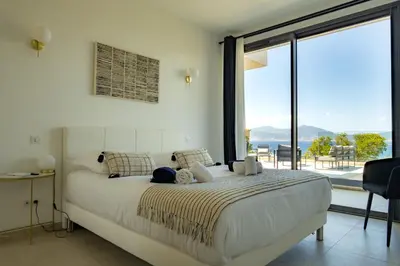 a bedroom with a large bed and a large window at VILLA IMPERIALE vue mer piscine in Pietrosella