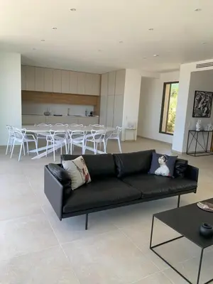 a living room with a black couch and a table at VILLA IMPERIALE vue mer piscine in Pietrosella