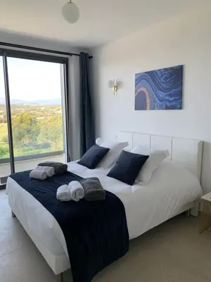 a bedroom with a large bed with towels on it at VILLA IMPERIALE vue mer piscine in Pietrosella